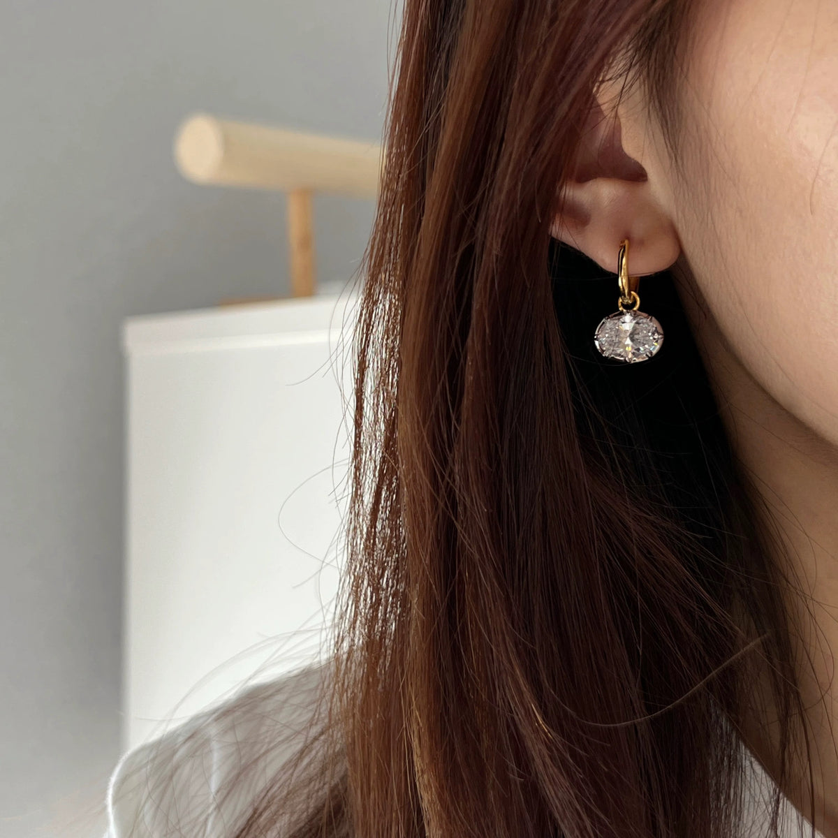 Hailey two-tone 925 sterling silver drop earrings with an oval 5A cubic zirconia, worn on the ear